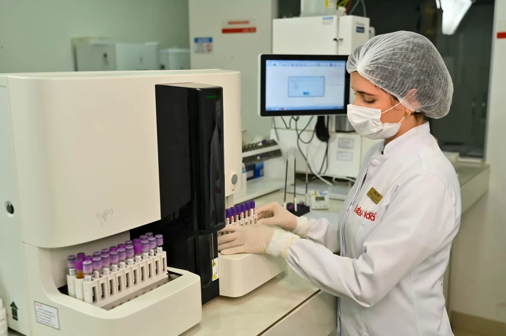 Colaboradora rodando exames na máquina.